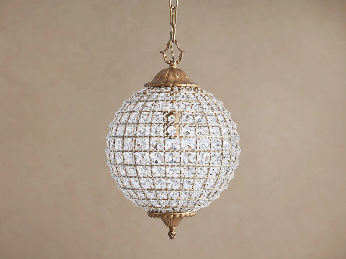 Spherical Poppy Chandelier with antiqued brass finish, covered in sparkling, multifaceted clear crystals, hanging from a chain.