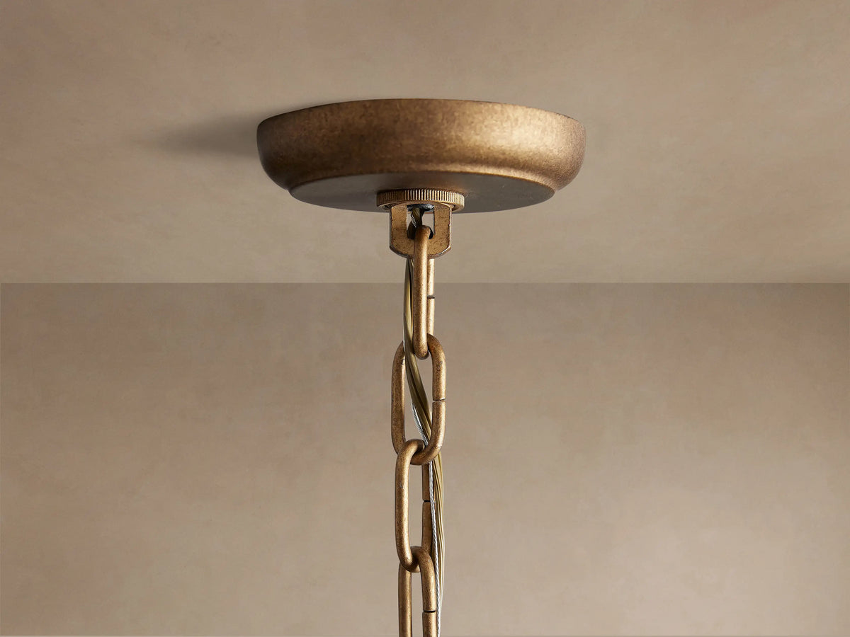 Poppy Chandelier close-up, bottom half. Spherical antiqued brass frame holds clear faceted crystals reflecting light.