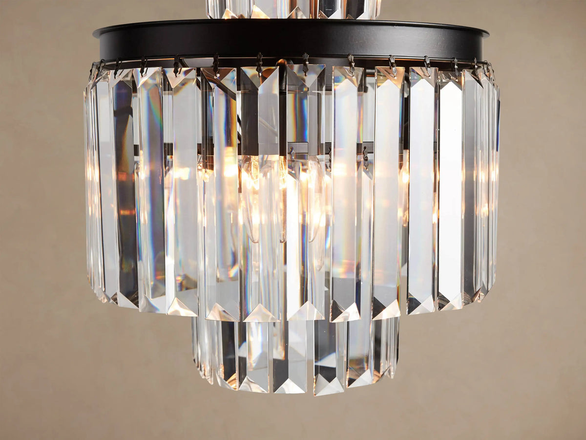 Leyland Chandelier: Multi-tiered fixture with an oil-rubbed black iron frame and clear faceted K9 glass crystals, illuminated.