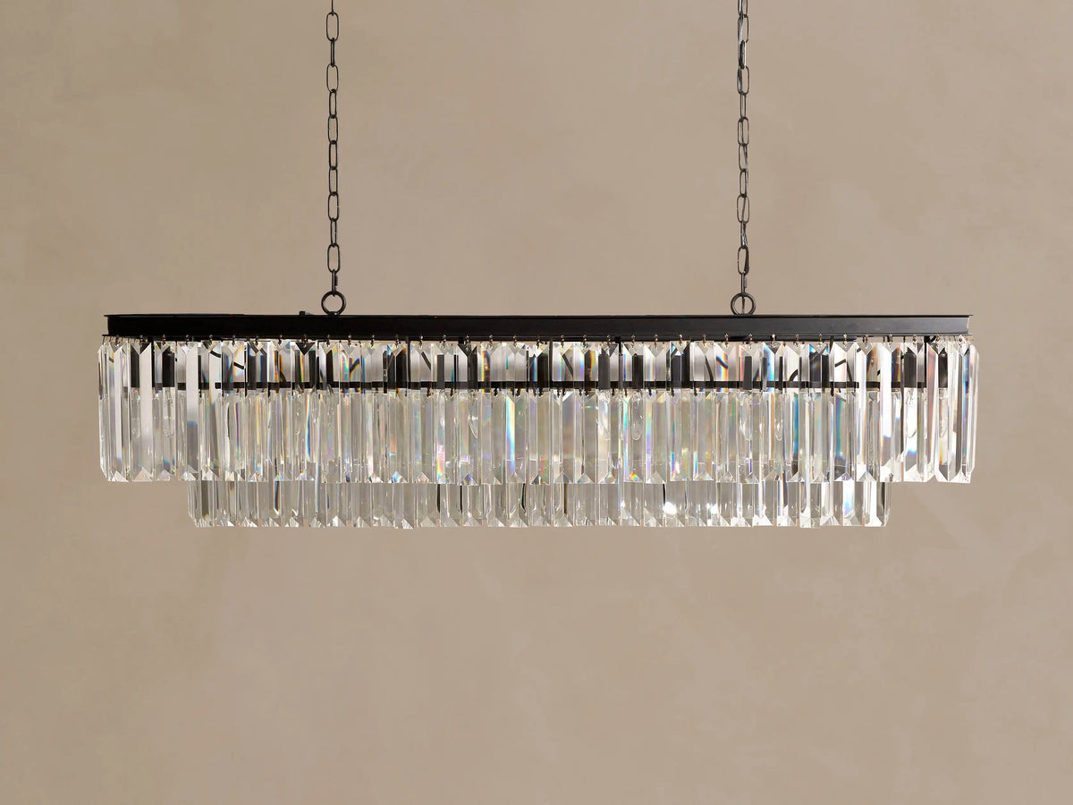 Leyland Tiered Rectangular Chandelier: dark frame with two tiers of glowing K9 clear glass crystals, hanging from chains.