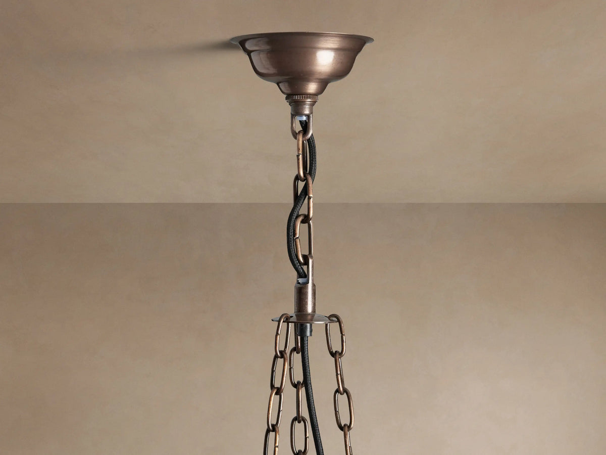 Laila Round Chandelier with antique copper frame & antiqued mirrored-glass panels, glowing with warm light.
