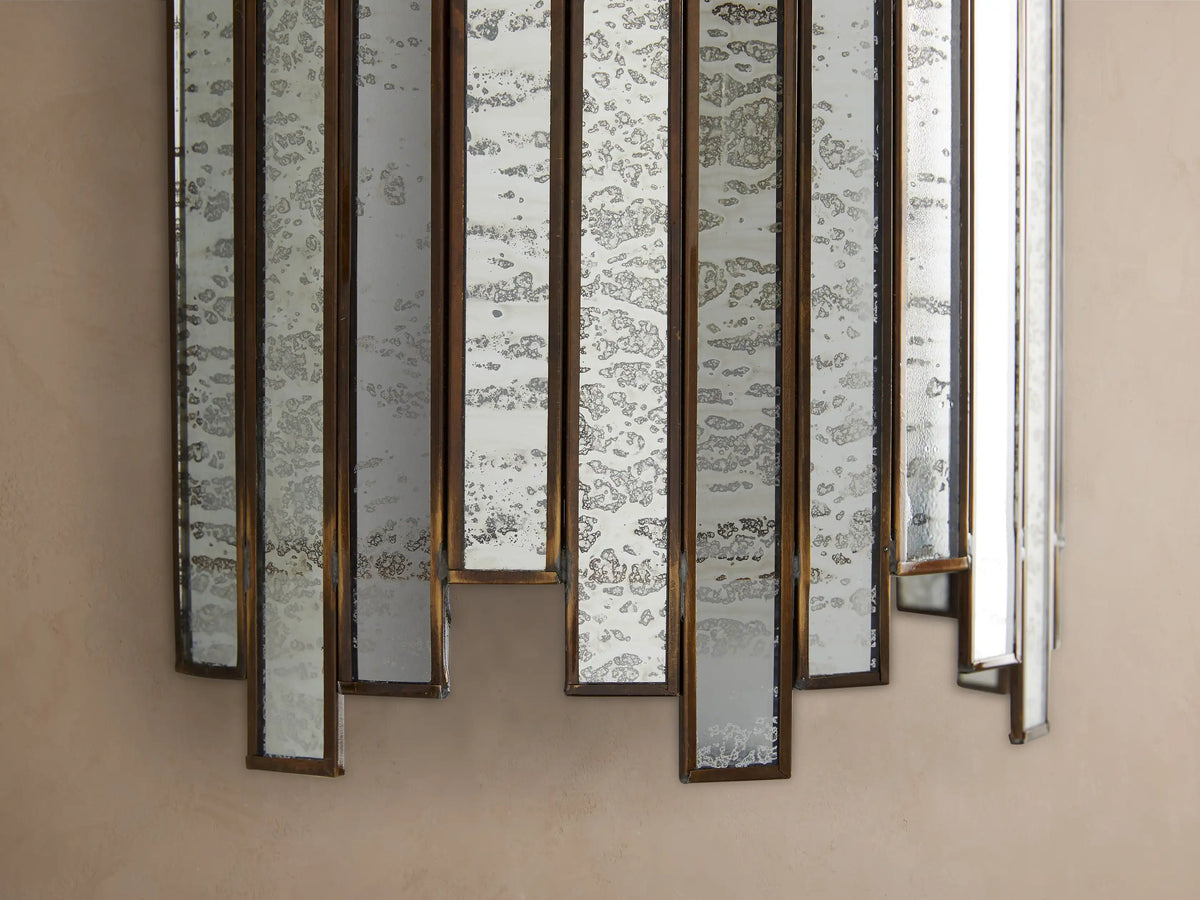 Laila Sconce: Vertical wall light with an antique copper frame holding multiple antiqued mirrored glass panels on a beige wall.