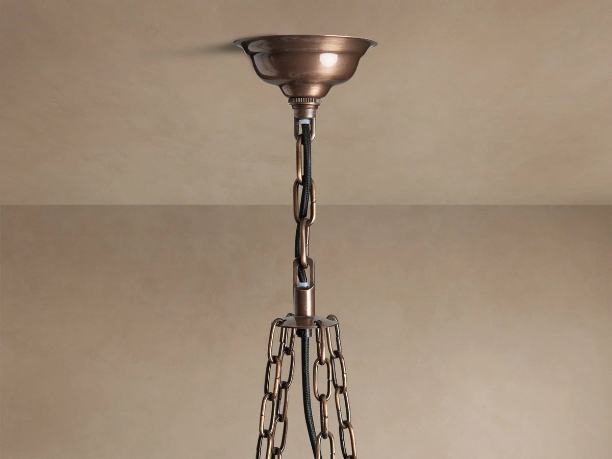 Laila Round Chandelier, antique copper frame with staggered, distressed mirrored-glass panels casting a warm golden light.
