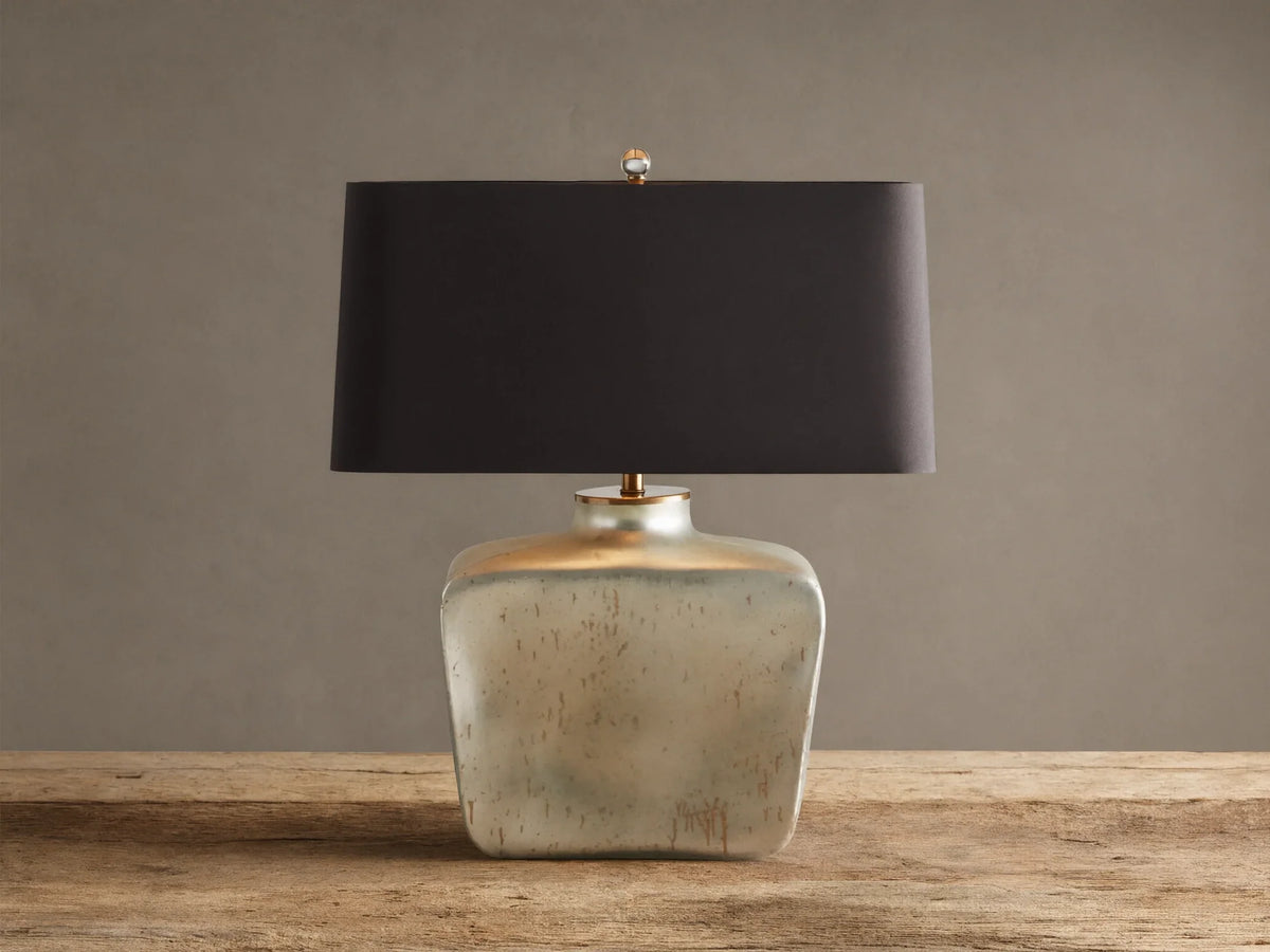 Balor Table Lamp: rectangular black shade, shimmering Antique Silver Rain glass base, gold finial, on wood.