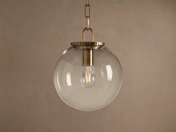 Wescott Globe Pendant: clear glass sphere with brass hardware and visible Edison bulb, hanging from a chain.