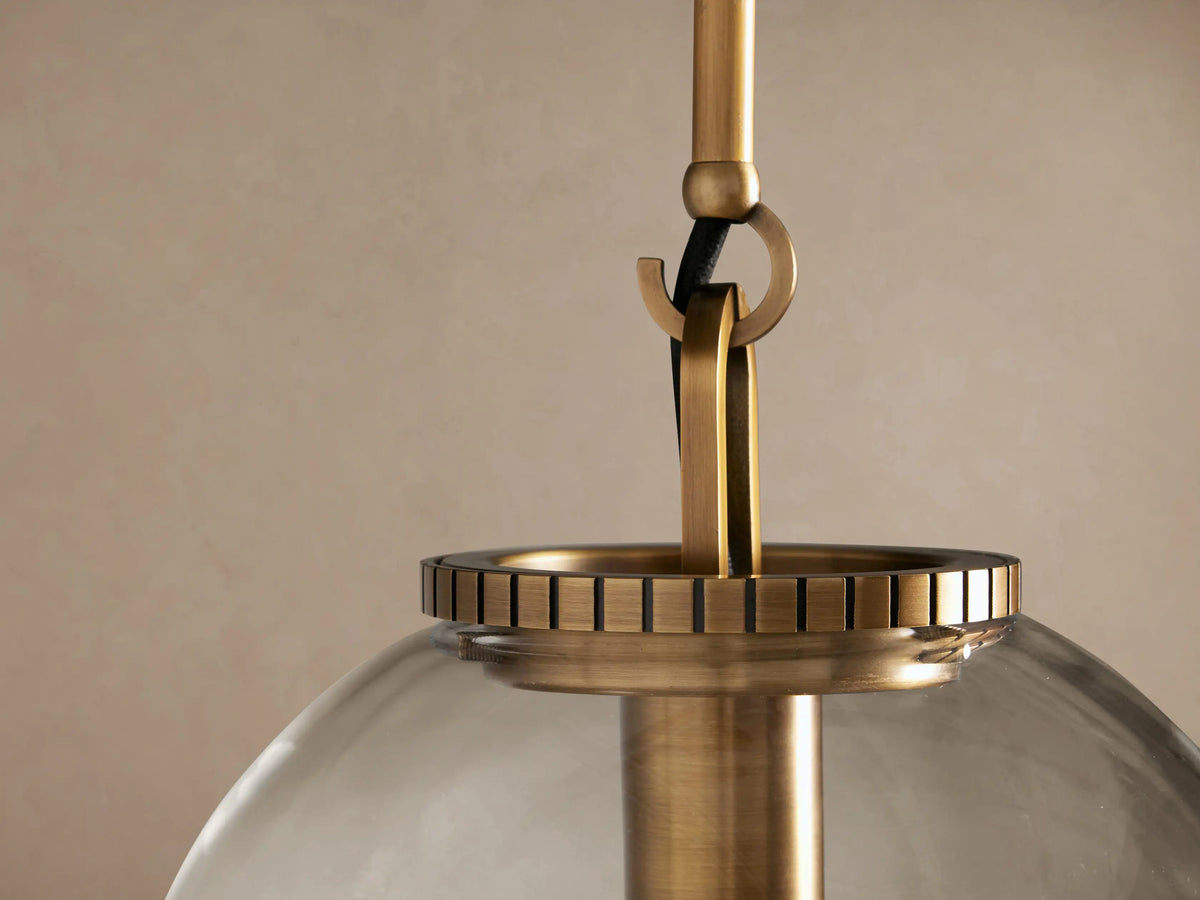 Wescott Globe Pendant: a clear glass globe with a visible filament bulb, suspended from a brass-finished rod.