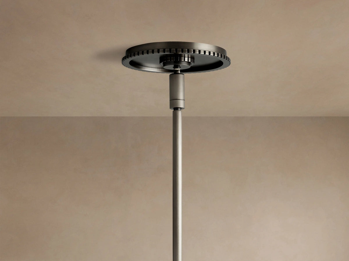 Wescott Globe Pendant close-up: dark bronze suspension rod, ribbed band, & top of clear glass globe on beige background.