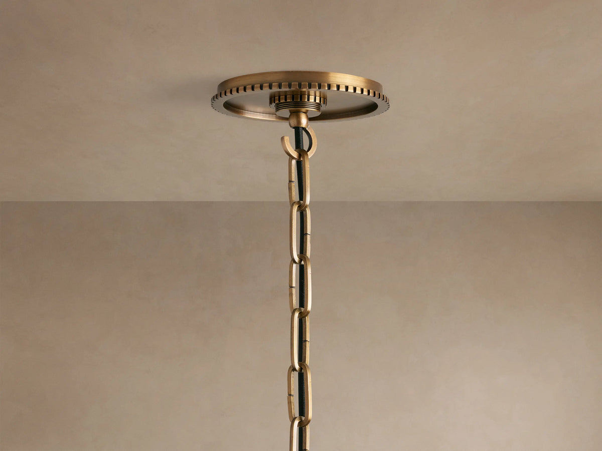 Wescott Globe Pendant close-up: Textured brass ring with dark vertical stripes connecting to a milky white glass globe.