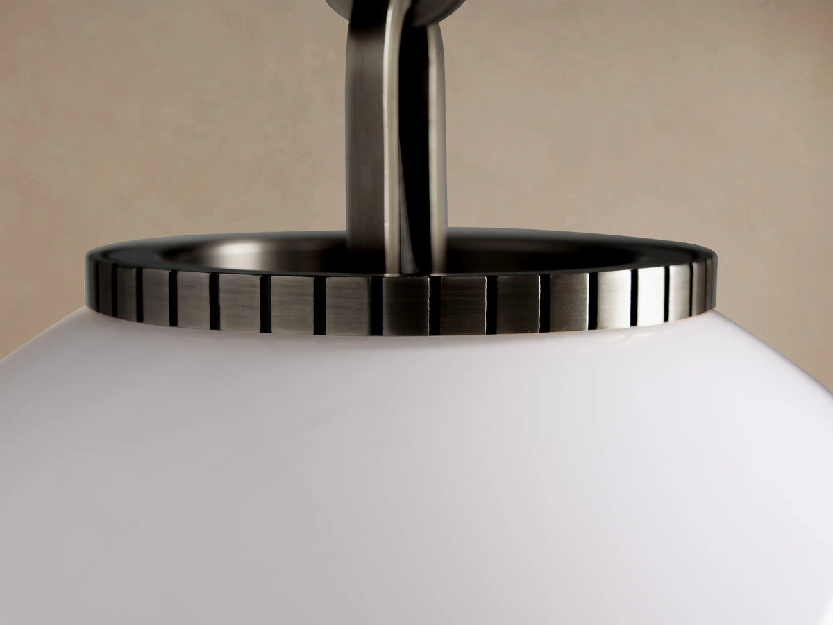 Wescott Globe Pendant with a smooth, reflective white milk glass globe suspended from a dark metallic rod.