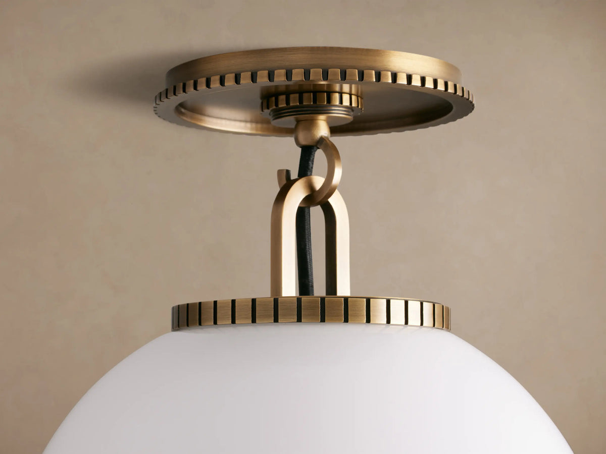 Wescott Globe Flush Mount with a brass finish and a white milk glass globe, mounted on a tan ceiling.