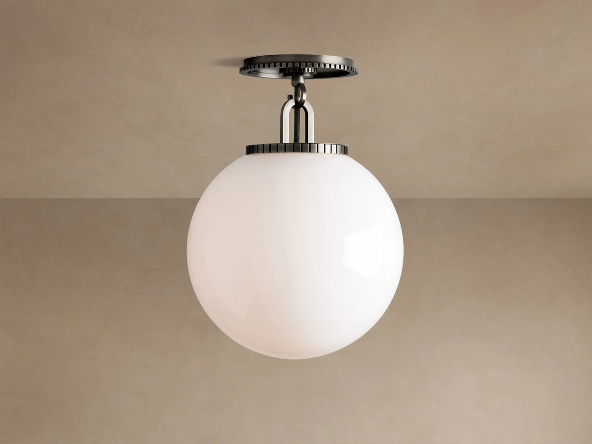 Wescott Globe Flush Mount with opaque white milk glass sphere and dark bronze hardware, against a light brown ceiling.