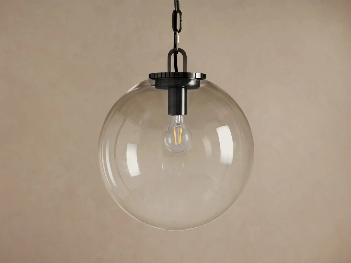 Wescott Globe Pendant with Chain. Large, slightly amber-tinted clear glass globe with dark bronze hardware and exposed bulb.