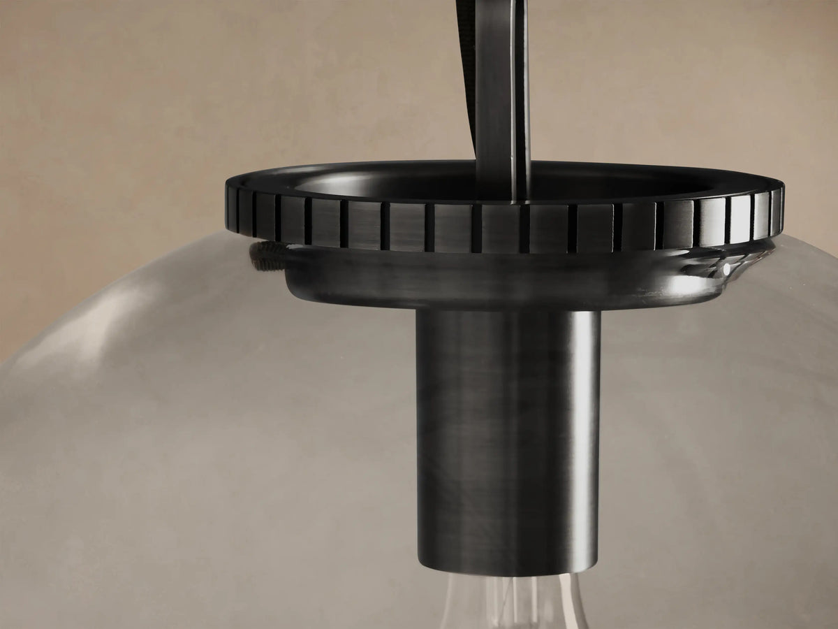 Wescott Globe Pendant: Clear glass globe with an exposed bulb, dark bronze fixture, and chain, against a light wall.