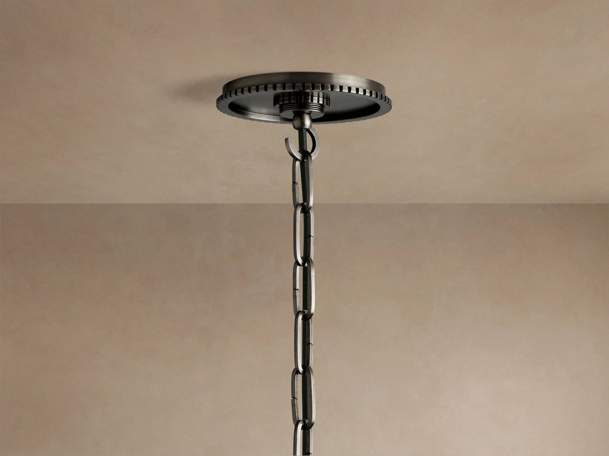 Close-up of Wescott Globe Pendant. Dark bronze metal fitting with ribbed ring connects to clear glass globe on light wall.