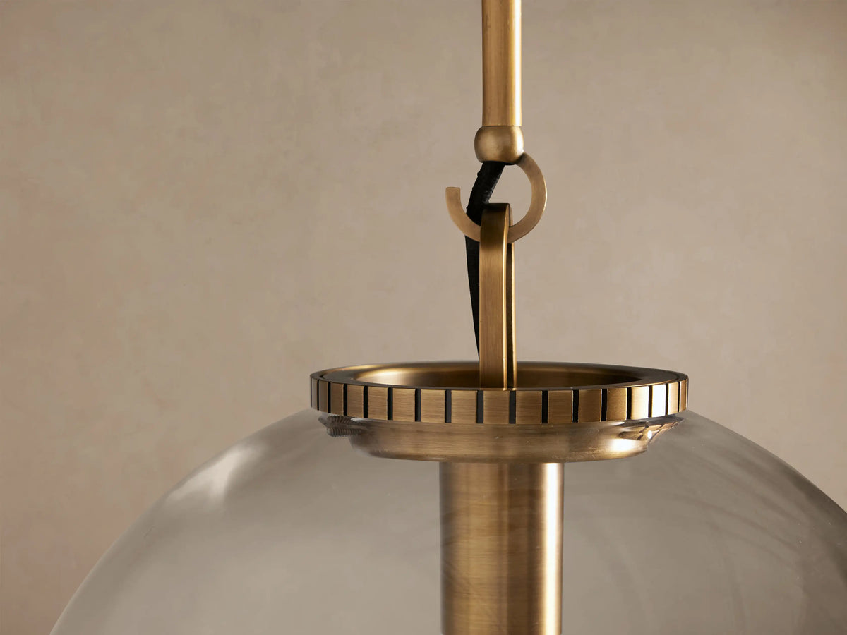 Wescott Globe Pendant light with clear glass globe shade, brass rod and fitting, showcasing an incandescent bulb inside.