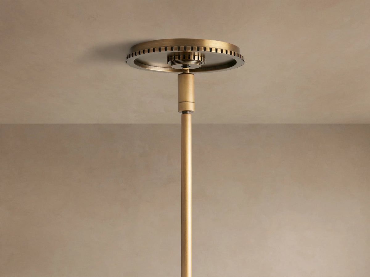 Close-up Wescott Globe Pendant: clear glass globe, ribbed brass band, and brass rod with black cord detail.
