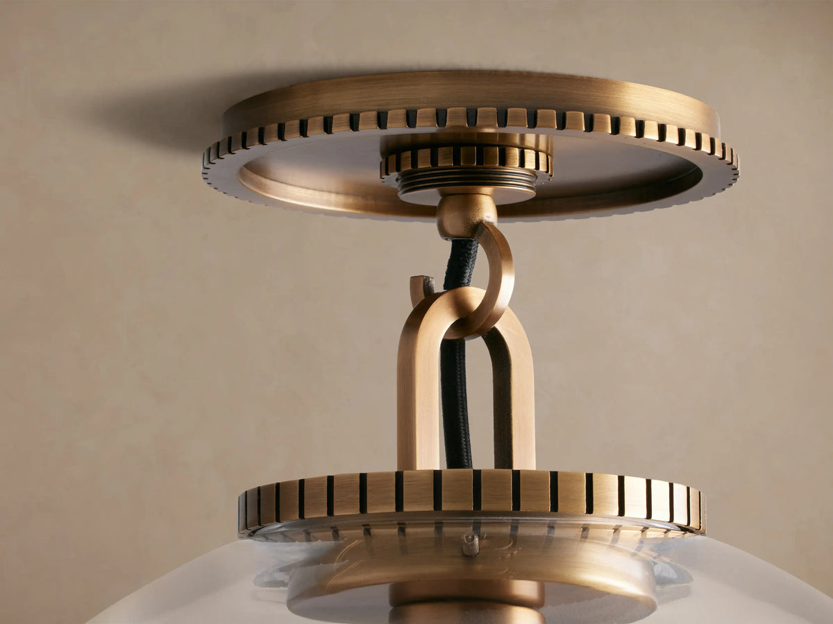 Wescott Globe Flush Mount, brass hardware, clear glass globe with visible filament bulb, against a beige ceiling.