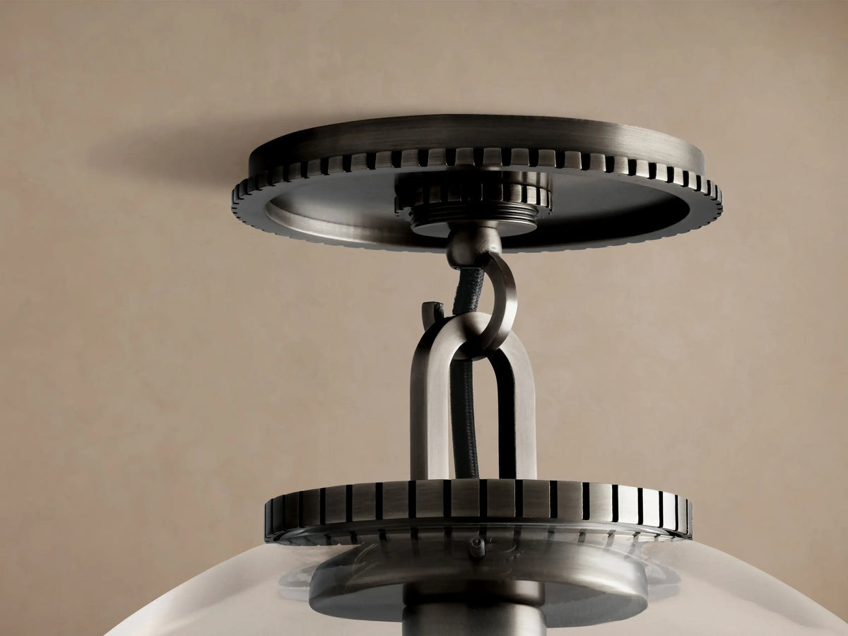 Wescott Globe Flush Mount: a clear glass sphere with an Edison bulb inside, suspended from dark bronze hardware on a beige ceiling.