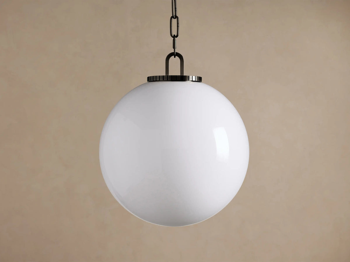 Wescott Globe Pendant: Large white spherical milk glass globe suspended by a dark metal chain against a beige wall.