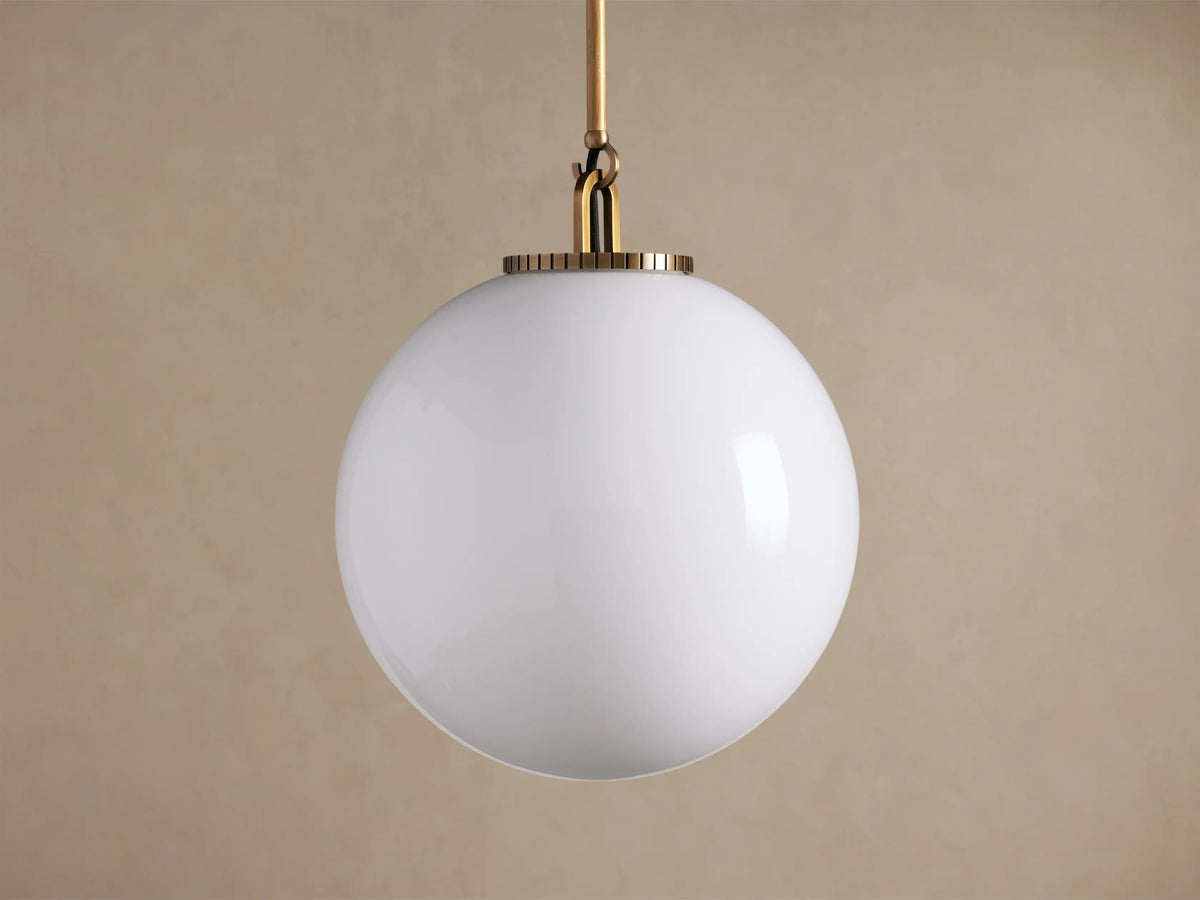 Wescott Globe Pendant with Rod: large glowing white milk glass globe suspended by a brass-finished rod against a neutral background.