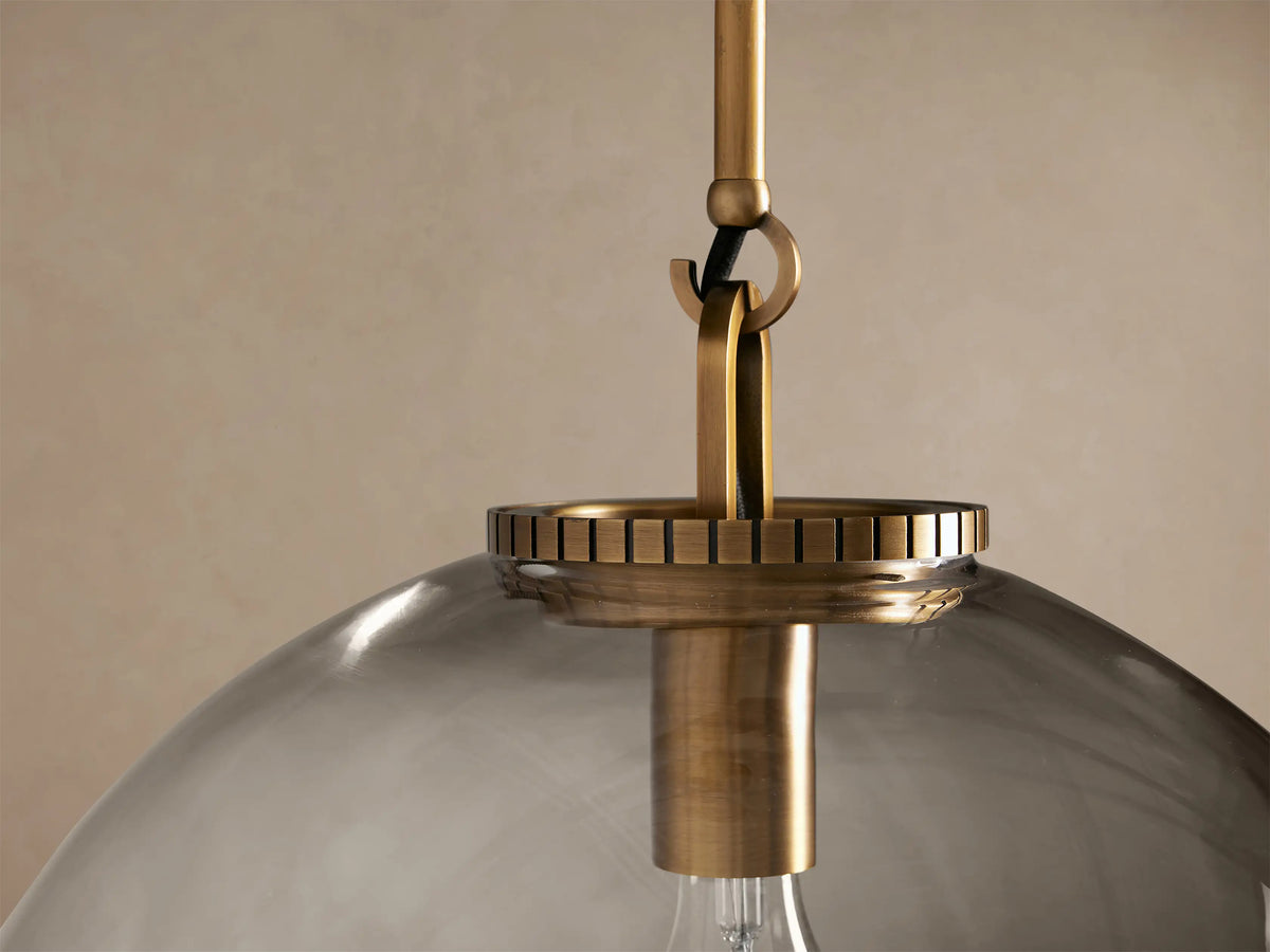 Wescott Globe Pendant with Rod, large clear glass globe, brass hardware, and exposed filament bulb, hanging against a light wall.