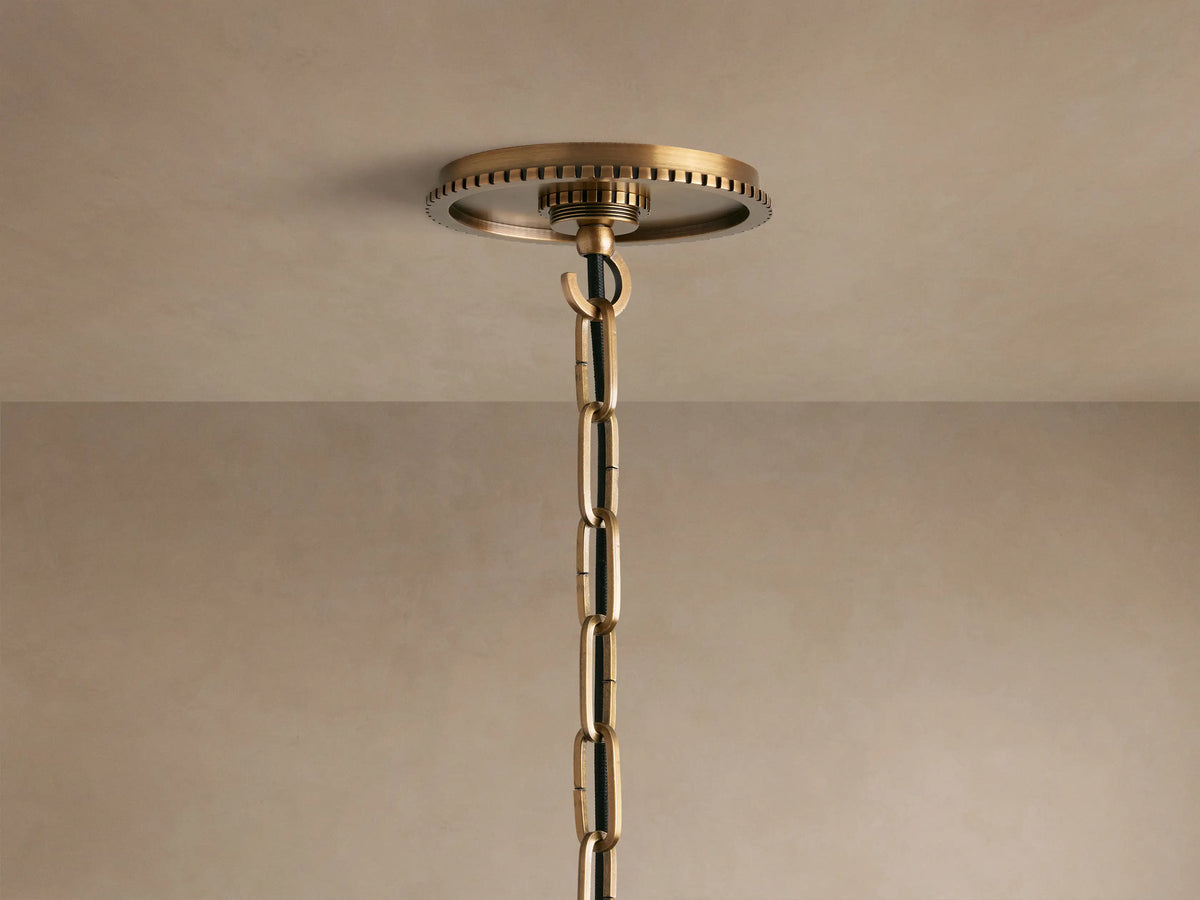 Wescott Globe Pendant: Close-up of a milky white glass globe meeting a brushed brass fitting with a ribbed textured band.