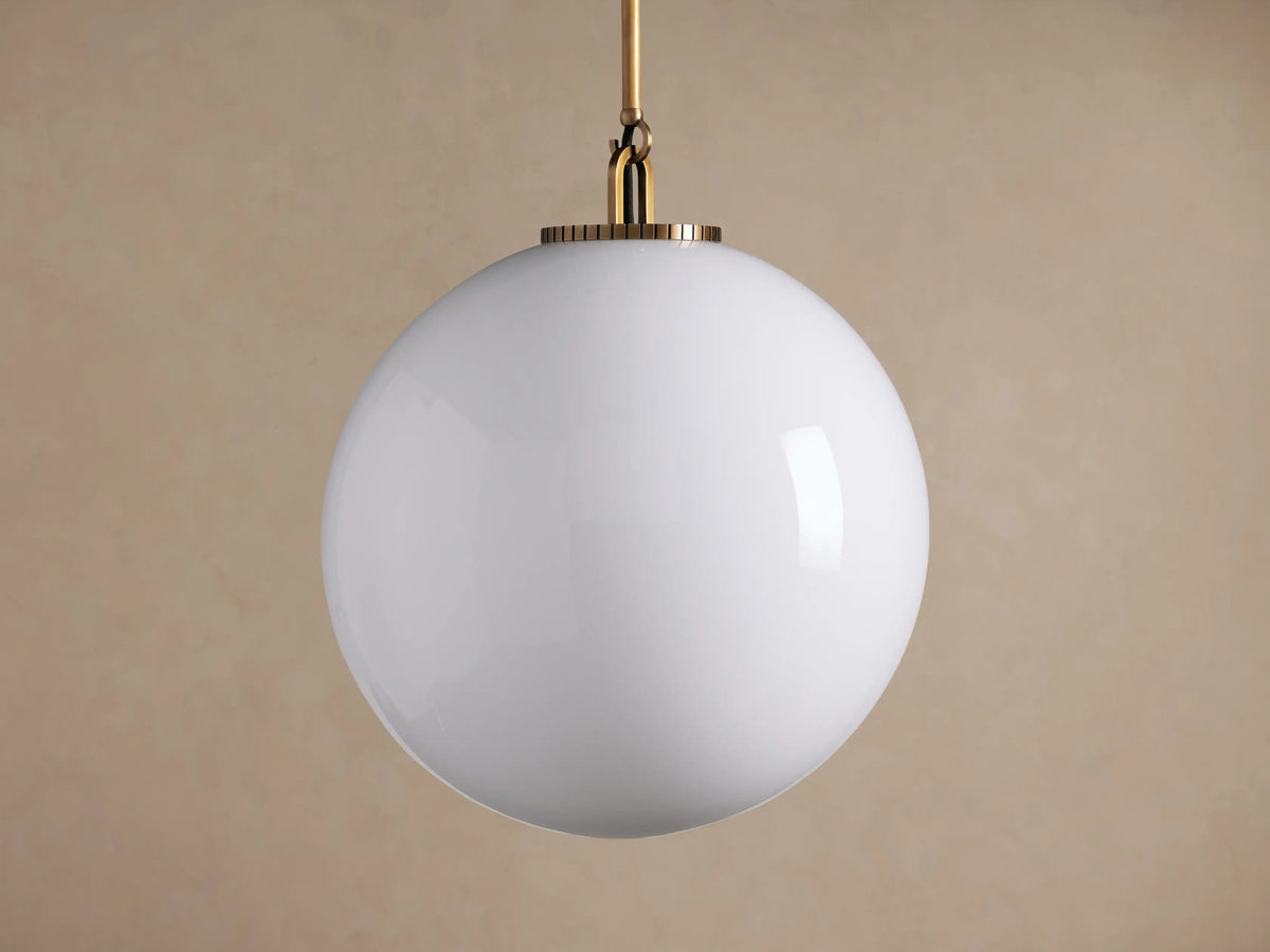 Wescott Globe Pendant: White milk glass sphere suspended from a thin brass rod, centered on a simple beige background.