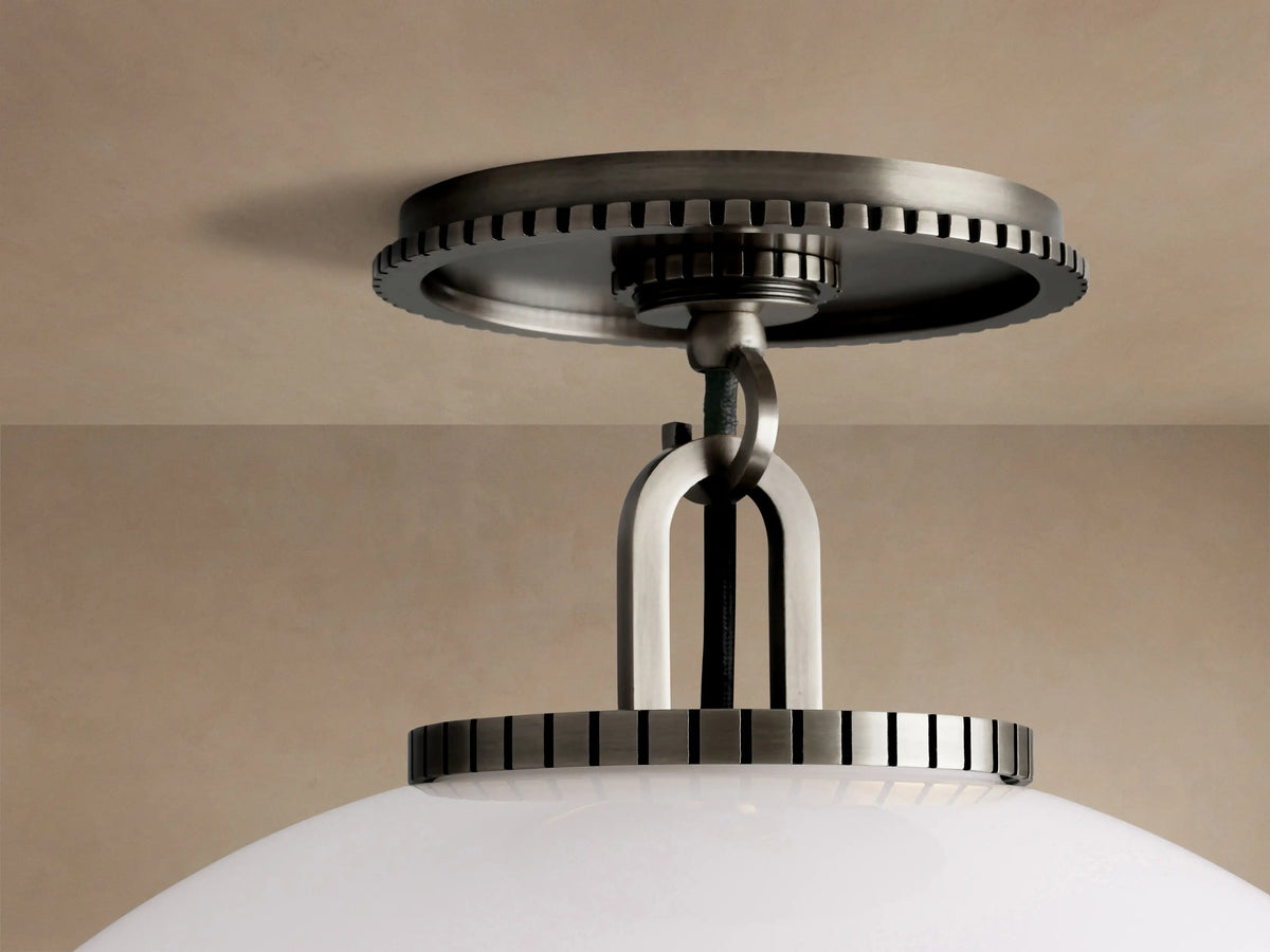 Wescott Globe Flush Mount. Large white milk glass sphere suspended from a dark bronze ceiling canopy on a light brown ceiling.