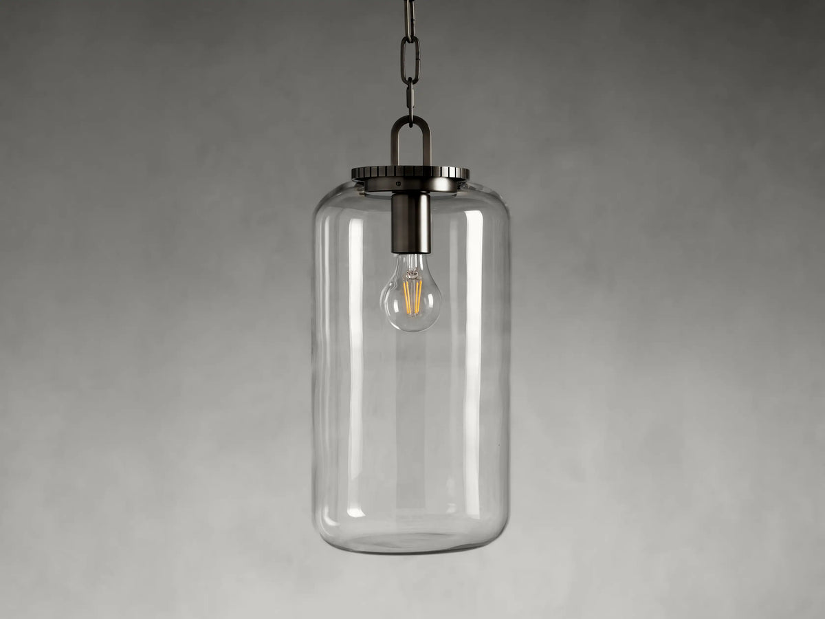 Wescott Cylinder Pendant with brass or bronze finish, clear glass shade, exposed bulb inside; black chain hangs from top.
