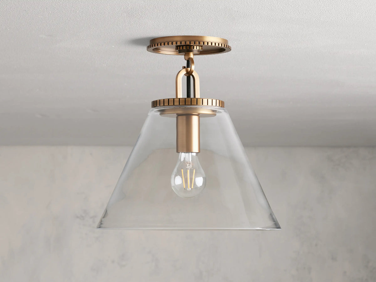 Wescott Cone Flush Mount with brass finish, clear glass cone shade, and visible bulb. Mount features textured details.