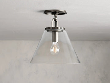 Wescott Cone Flush Mount with clear glass cone shade, visible bulb, and brass finish, mounted on a white ceiling.