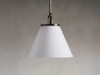 Wescott Cone Pendant with Rod in a brass finish, featuring a clear glass cone shade, hanging by a metal rod against a gray background.