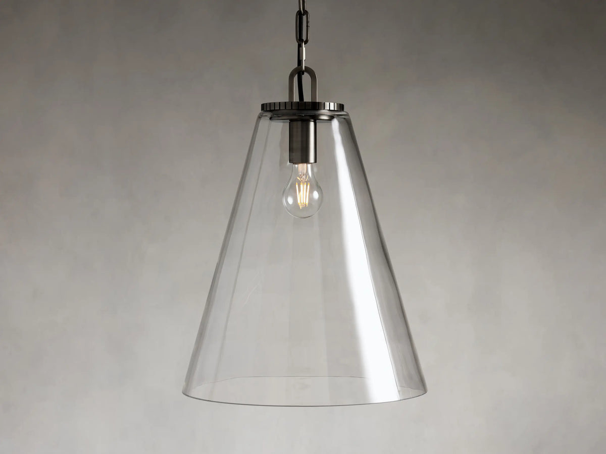 Clear glass cone-shaped pendant light with steel fixture, suspended by a black chain. Single visible bulb interior against a soft gray background.