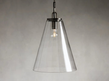 Clear glass cone-shaped pendant light with steel fixture, suspended by a black chain. Single visible bulb interior against a soft gray background.