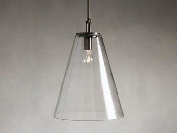 Clear glass cone pendant light with visible bulb and dark metal fixture, suspended from a rod against a gray background.
