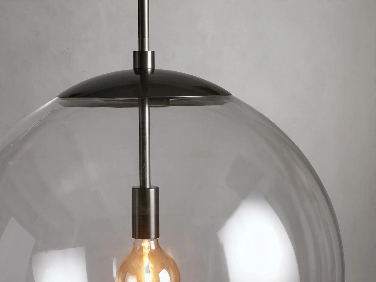 Clear glass globe pendant with a visible bulb, black rod and cap, against a neutral background, part of the Wescott XL collection.