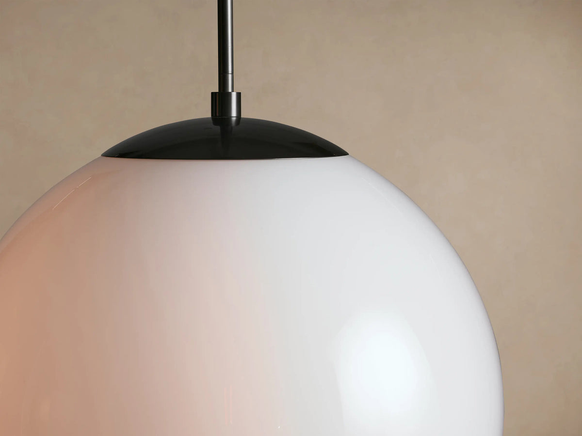 Wescott XL Globe Pendant, featuring a large opaque white milk glass globe, dark metal cap, and thin hanging rod.