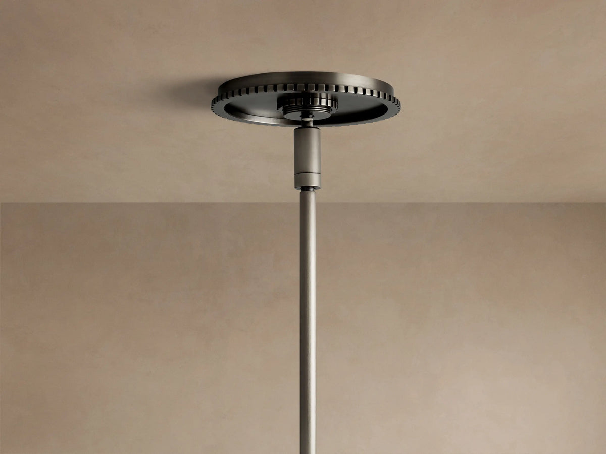 Close-up of Wescott XL Globe Pendant. Large white milk glass globe, dark bronze cap, and hanging rod against a beige wall.