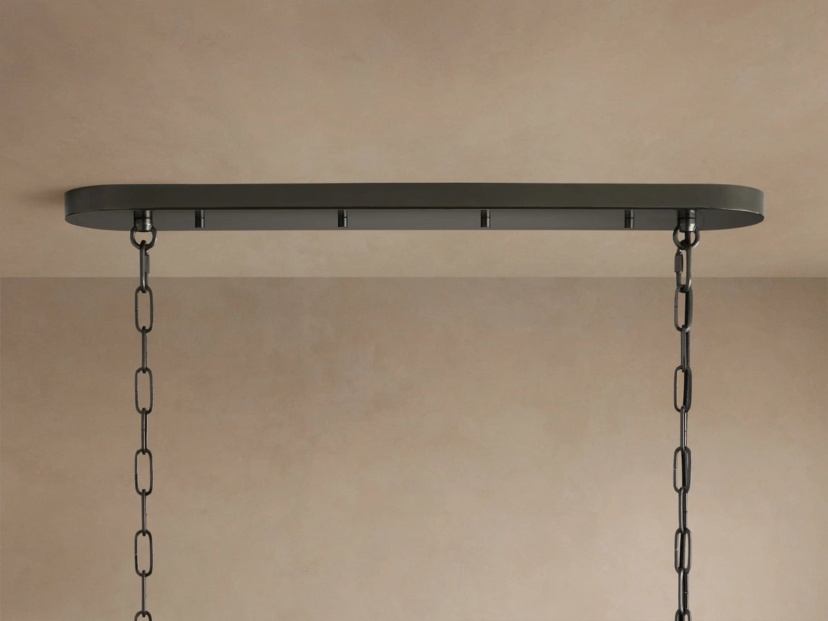 Ghiaccio Oval Chandelier close-up: clear, textured, curved glass ribbons arranged in wavy tiers on a dark frame.