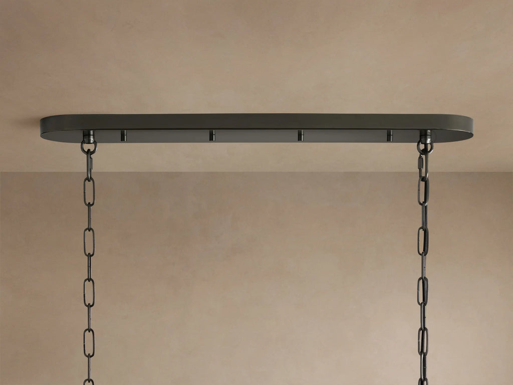 Ghiaccio Oval Chandelier close-up: clear, textured, curved glass ribbons arranged in wavy tiers on a dark frame.