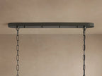 Ghiaccio Oval Chandelier close-up: clear, textured, curved glass ribbons arranged in wavy tiers on a dark frame.