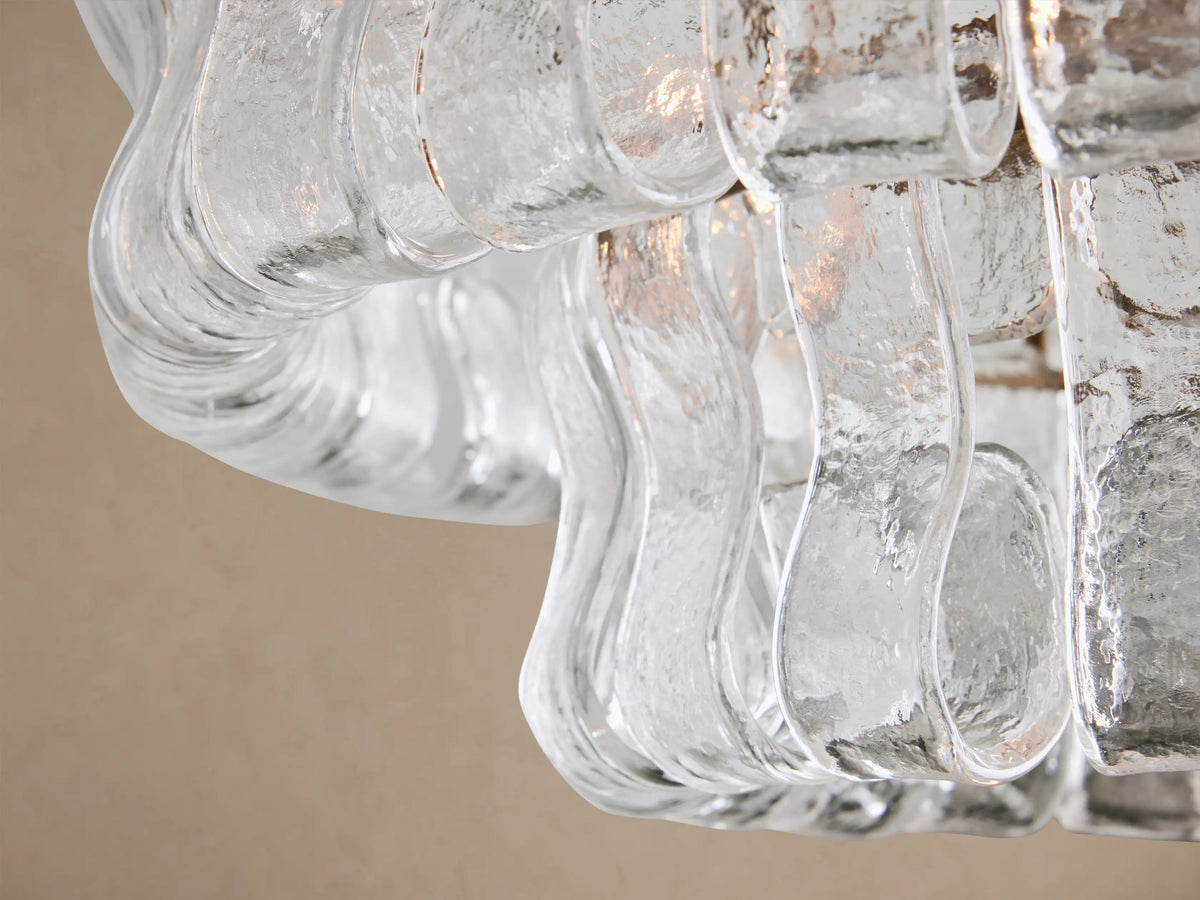 Ghiaccio Flush Mount, a circular light with a brass base and textured, clear wavy glass strips, mounted on a ceiling.