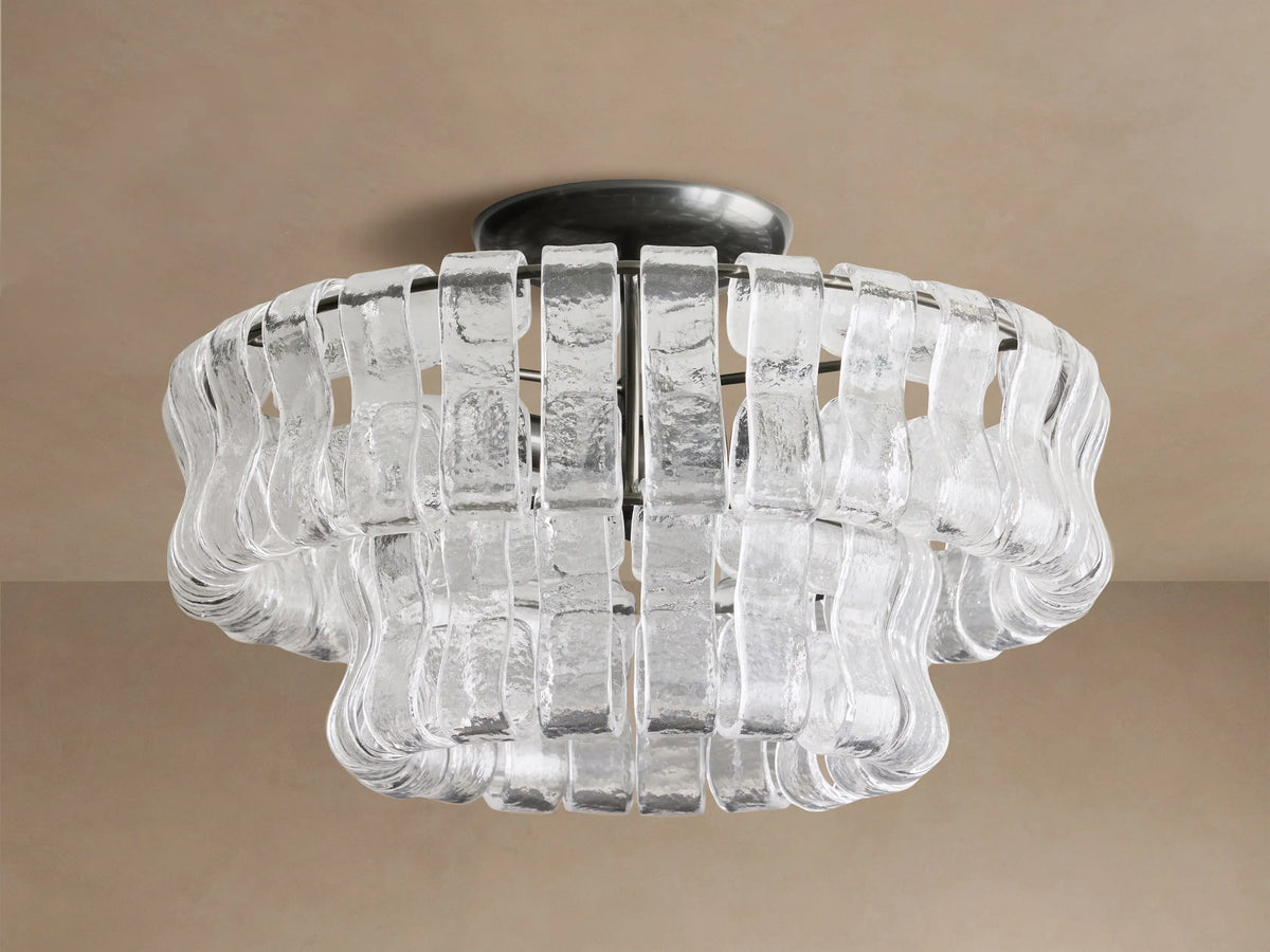 Ghiaccio Flush Mount with a dark steel base and layered, textured clear glass pieces forming a wavy, sculptural design. Soft glow.