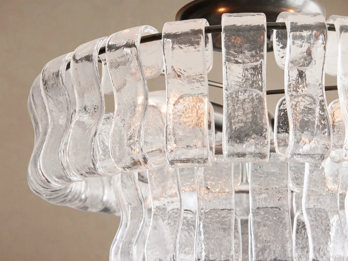 Ghiaccio Flush Mount featuring a layered shade of clear, textured, wavy glass panels, with a dark metal base.