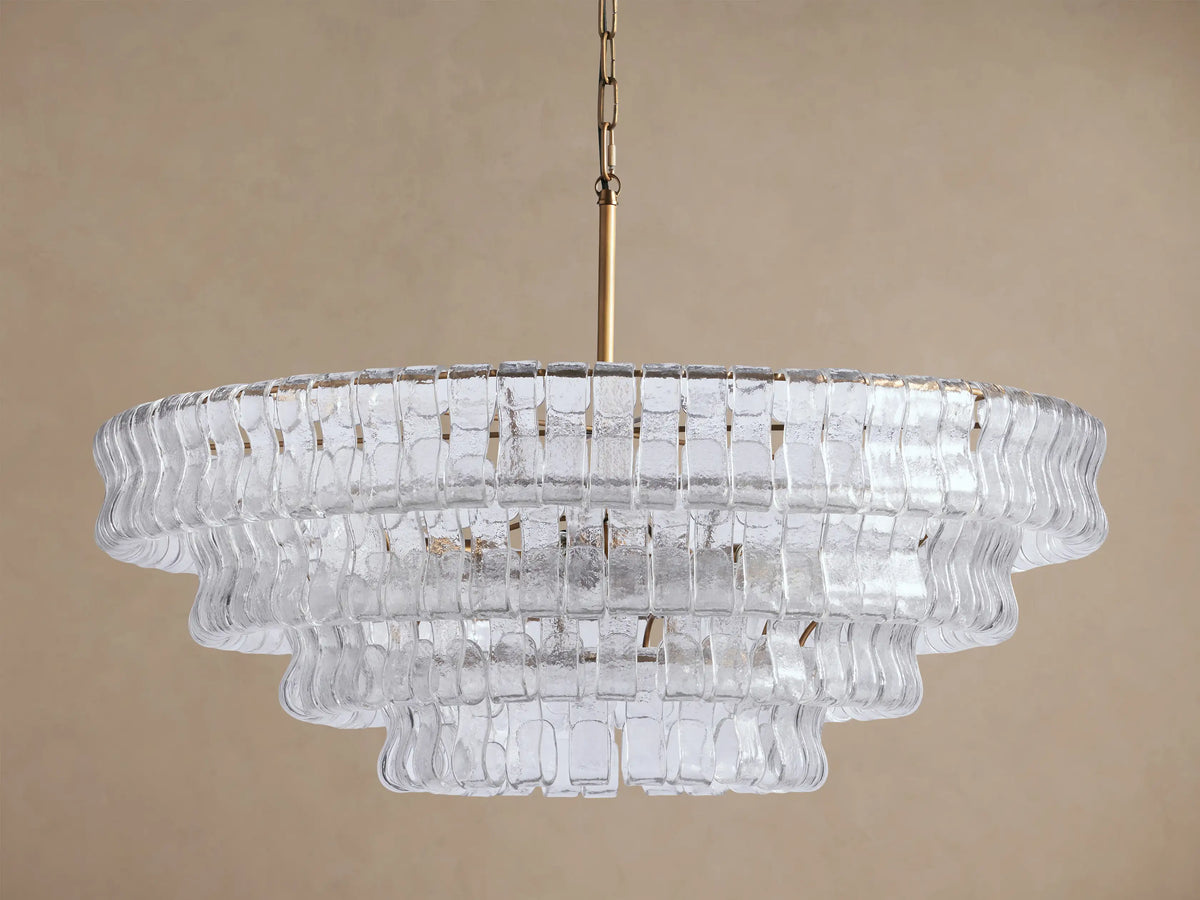 Ghiaccio Round Chandelier with textured, clear curved glass panels in multiple tiers, suspended by a brass chain.