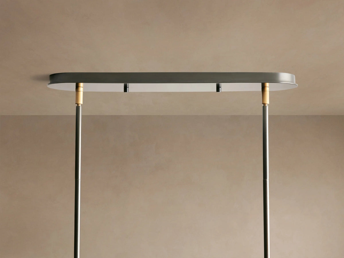 Close-up of Daphne Linear Chandelier showing white fabric shades with black trim, connected by a black rod with bronze accent.