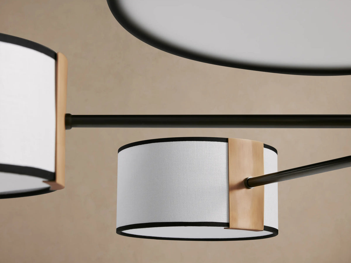 Daphne Fabric Round Chandelier with 8 white linen shades, black trim, and dark steel frame with bronze accents, hanging.
