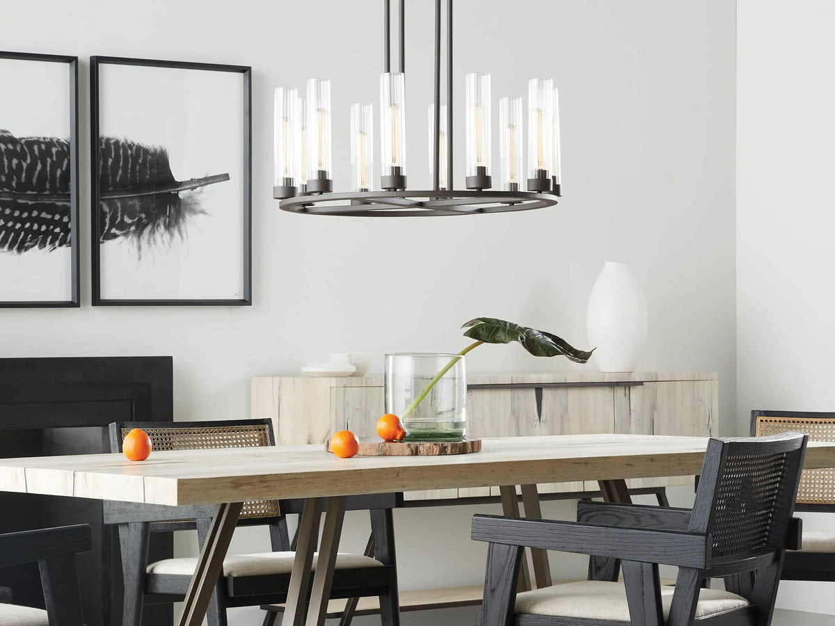 Round chandelier with a dark bronze finish, featuring ten upward T9 bulbs in clear cylindrical glass shades, against a gray background.