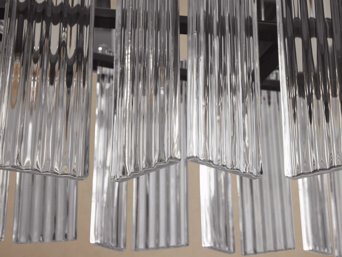 Close-up of Delsie Oval Chandelier showing clear, ribbed glass panels hanging from a dark metal frame.
