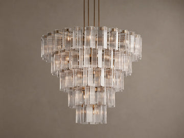 Delsie Round Chandelier: Tiered design with numerous clear vertical glass rods, burnished brass frame, brightly lit.